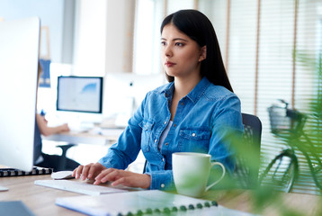 Asian woman typing on computer keyboard