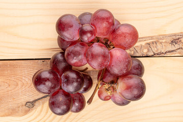 Lot of whole fresh red globe grape on wood