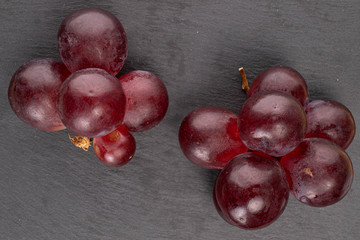 Lot of whole fresh red globe grape on grey stone