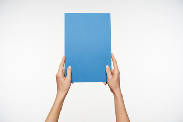 Studio photo of rectangular piece of paper being held by young lady's hands upright, posing against white background. Human signs and gesturing concept © timtimphoto