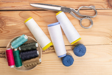Sewing scissors with thread spools on wood