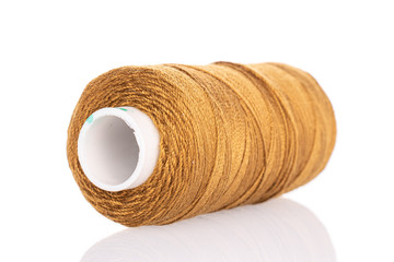 One whole golden thread spool isolated on white