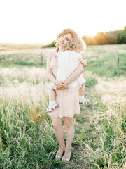 Mother and daughter having fun in the park. Happy family concept. Beauty nature scene with family outdoor lifestyle. Happy family resting together. Happiness and harmony in family life.