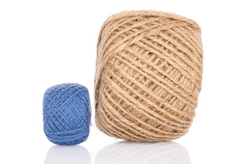 Group of two whole blue and beige thread spools isolated on white