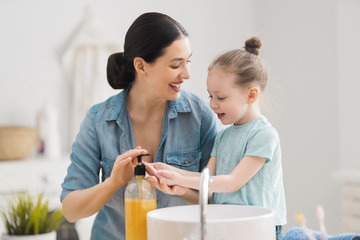 Obraz premium girl and her mother are washing hands