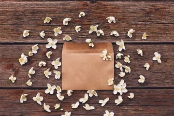 Jasmine flowers in an envelope on a wooden background.