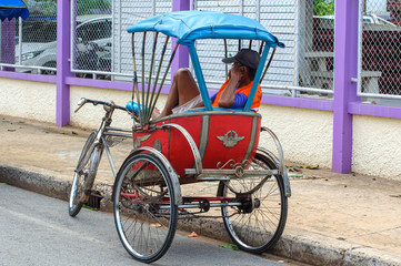 Traditional Thai transport - trishaw or tricycle on an empty street waiting for customer.