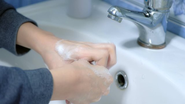 Child boy washing hands with antibacterial soap in sink, hands closeup. Fighting spread of coronavirus infection covid-19. Hygienic procedures at home on quarantine and isolation during pandemic.