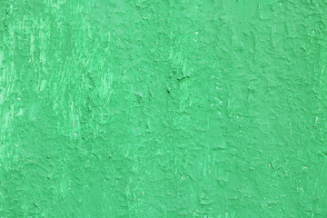 Beautiful vintage green background with old green paint with a rough surface, streaks and uneven texture of green paint on an old rough surface