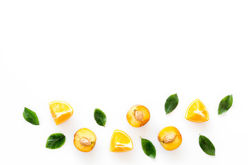Peach slices and leaves pattern on white background top-down frame copy space