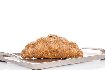 One whole baked wholegrain croissant on tray isolated on white