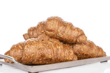 Group of three whole baked wholegrain croissant on tray isolated on white