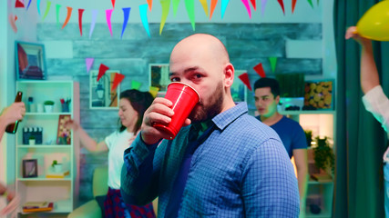 Zoom in shot of young man drinking alcohol