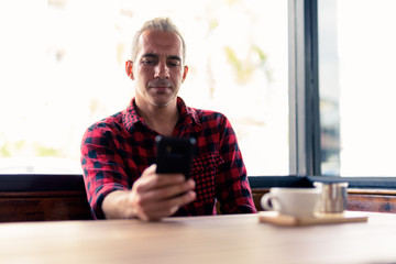 Portrait of Persian man using phone at the coffee shop