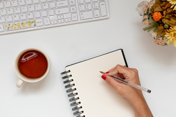 Top down image of girl hand writing in blank page. Planning academic facts. Flat lay