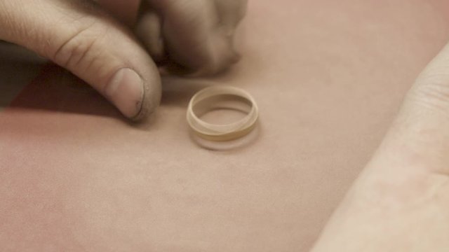 goldsmith smoothes a ring with emery paper, close up