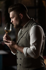 Professional sommelier man with a glass of white wine.