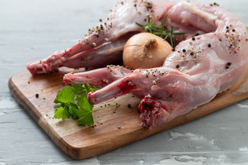 raw rabbit with onion and pepper on wooden board