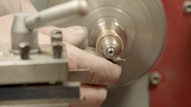 jeweler, goldsmith smoothes a ring with emery paper and a machine