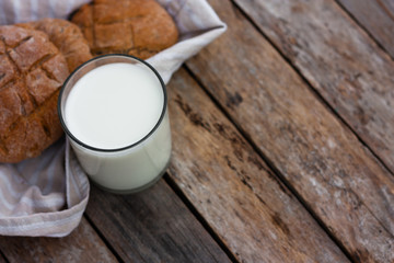 Glass of fresh milk and round brown rye flatbread on a rustic wooden table. Vegetable milk, vegan milk, Kefir, or Turkish Ayran drink for helthy eating. Space for text. Top view