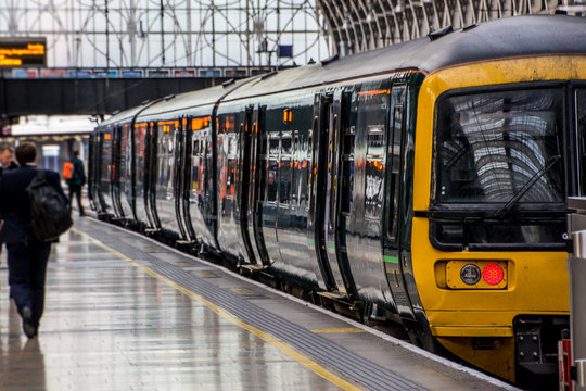Motion blurred passengers on railway station platform