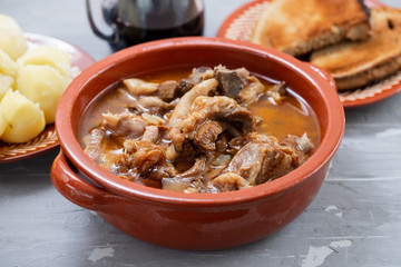 baked lamb with onion and pepper in the brown ceramic bowl