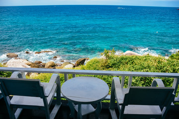 Nice sea view from a balcony of a hotel. Chair with table set on balcony hotel room with ocean view background.