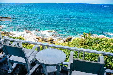 Nice sea view from a balcony of a hotel. Chair with table set on balcony hotel room with ocean view background.