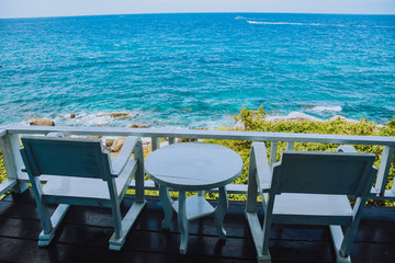 Nice sea view from a balcony of a hotel. Chair with table set on balcony hotel room with ocean view background.