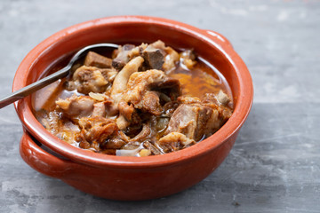 baked lamb with onion and pepper in the brown ceramic bowl