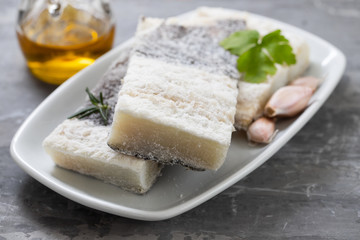 dry cod fish on white plate on ceramic background