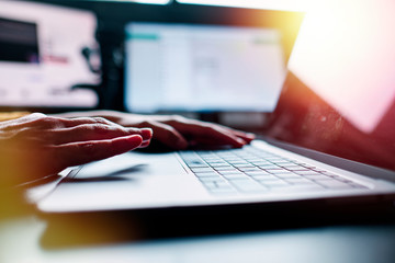 a closeup image of a woman working and typing on laptop computer keyboard