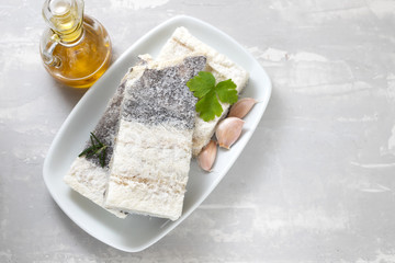 dry cod fish on white plate on ceramic background