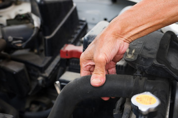Mechanic checks the pressure in the radiator hose for safety