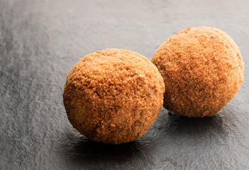 Scotch eggs on black stone background