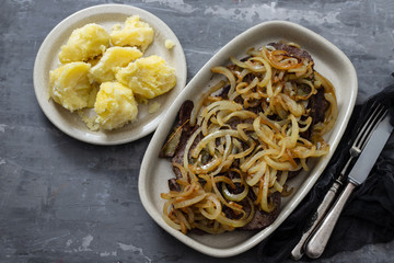 fried liver with onion on the dish on ceramic background
