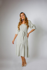 Beautiful blonde model posing in green  fashion dress and colored kerchief