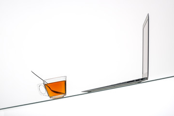 orange with tea cup and laptop on glass table surface