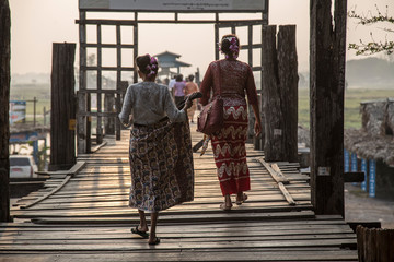 Pyin oo lwin, Myanmar '; Spring 2018: Two women in traditional dresses at Sunset at U Bein Bridge...