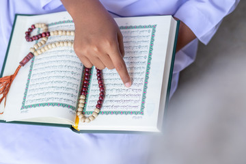 
Concept: open book holy prayers for god, Quran - holy book of Muslims religion, Friday In the month of Ramadan  religion Islamic worshiping faith and learn koran and rosary put on wooden  boards