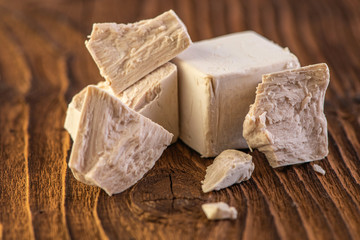 close up detail of fresh yeast cube  on a vintage old wood background 