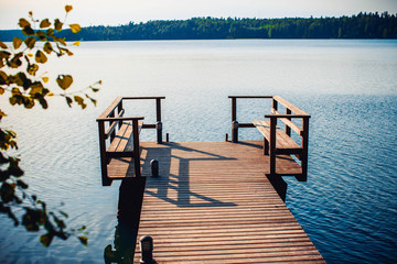 Long wooden pier and beautiful lake Saimaa, Finland on warm and windless summer day.