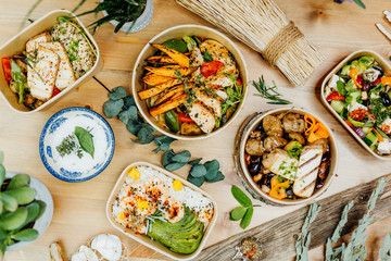 Various healthy and vitamin-rich dishes and food in an ecobox delivered by a delivery service, ordered online, decorated with bundles of straw, mussels and cacti, in a Mediterranean style