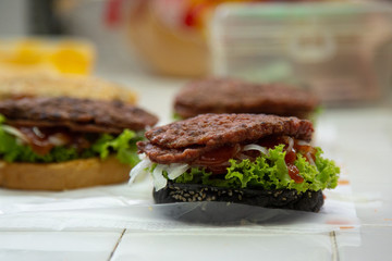 hamburger fast food  meal delicious American in the  restaurant,
burger  Decorated with onion cherry tomatoes, Close-up of homemade tasty burgers on wooden table, Craft beef burgers with vegetables
