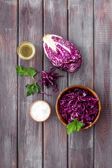 Red cabbage - cut head and sliced - on wooden kitchen table top view