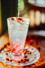 Iced Rose syrup with soda topped with rose petals on wood table, Summer refreshment drinks