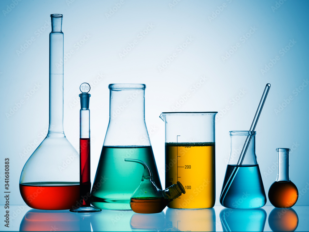 Wall mural different laboratory glassware with color liquid and with reflection