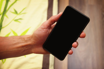 young man holds in his hand your phone with a black screen. phone at arm's length.