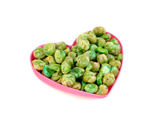 Green peas roasted with pink heart shaped cup isolated on white background