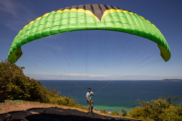 Paragliding pilot open the wing next to beach in beautiful island, Thailand